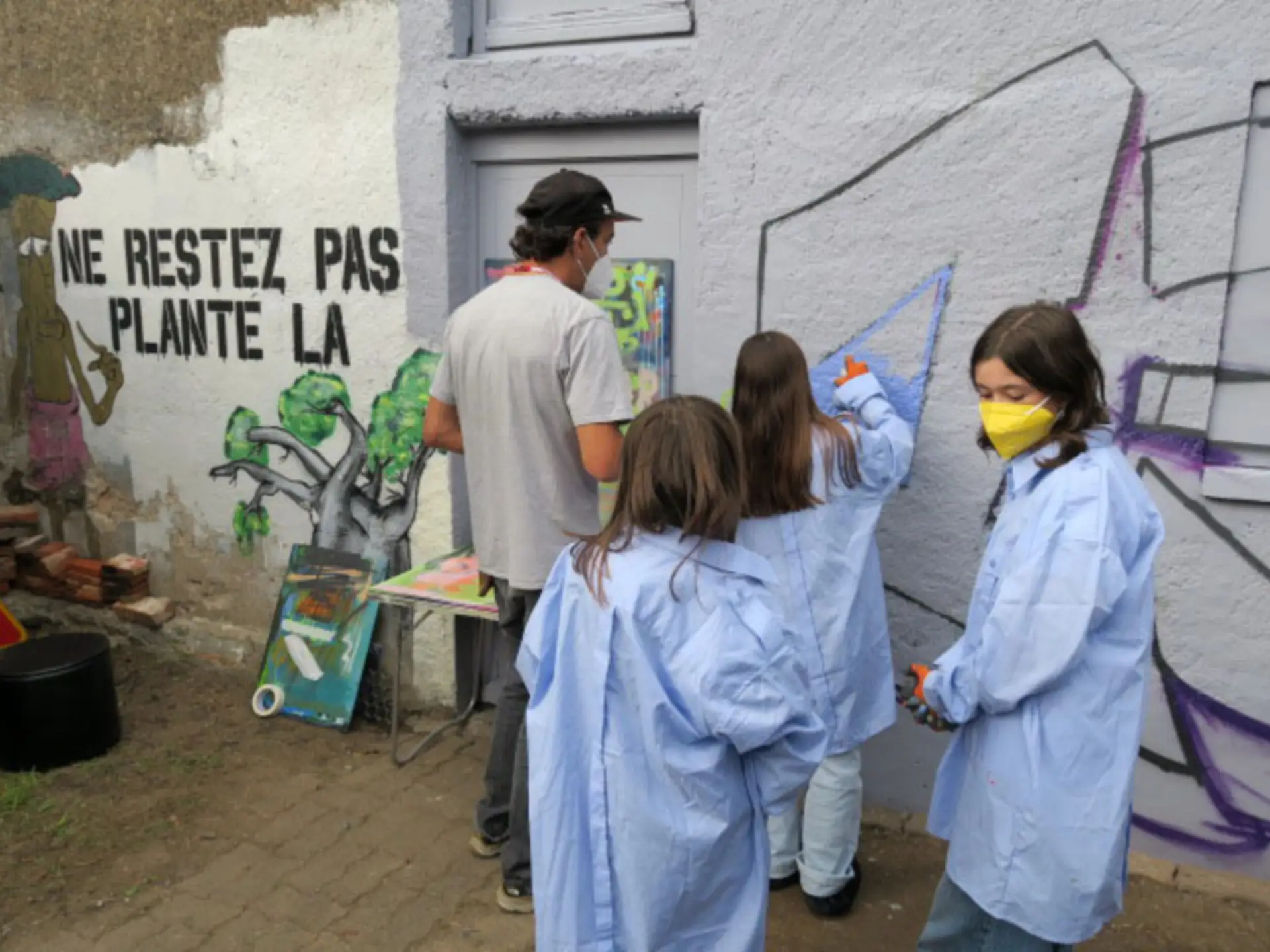 rassemblement de personnes dans la cours de l'association, un jeune fait du hiphop au milieu
