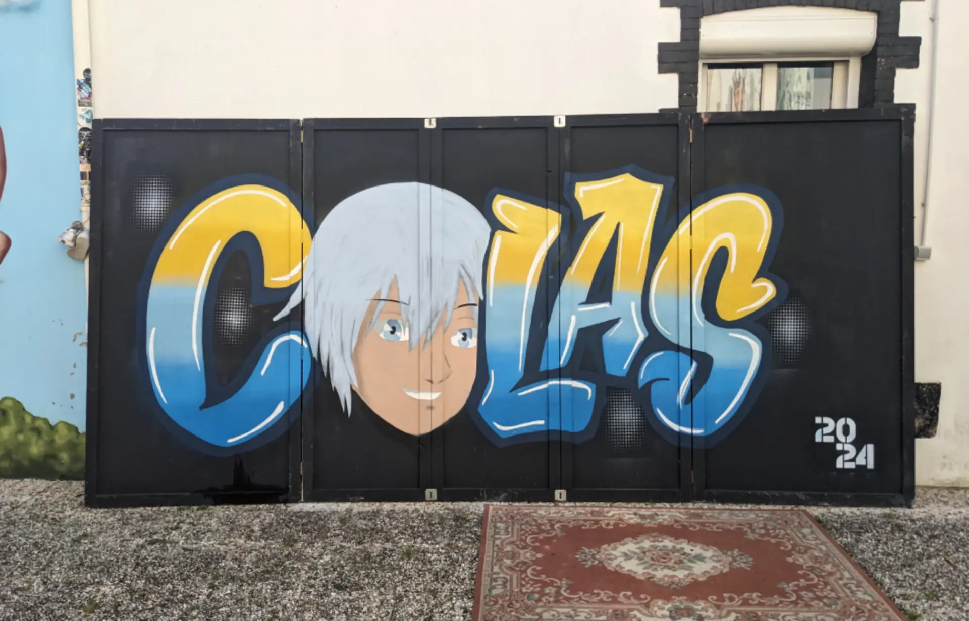 peinture marqué colas en degradé bleu jaune et le O de colas est un personnage