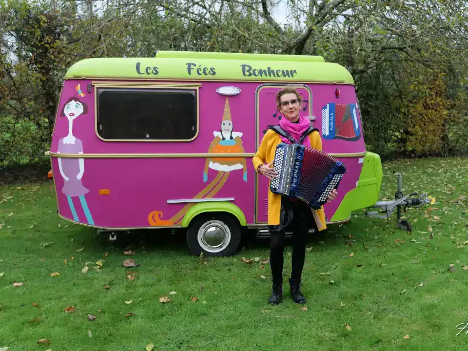 une caravane peinte en rose avec des marionettes