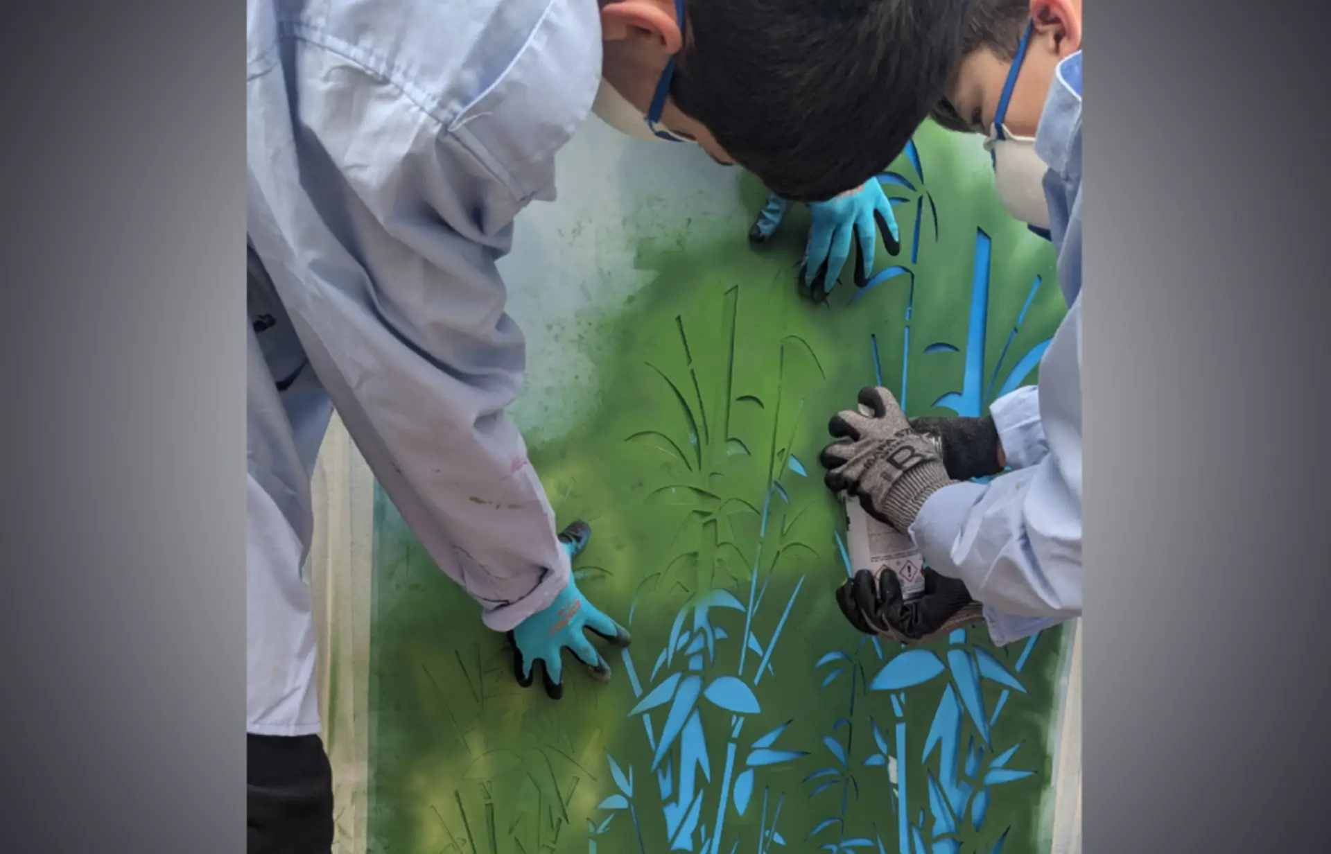 deux enfant en train de peindre a la bombe aerosol sur des pochoirs